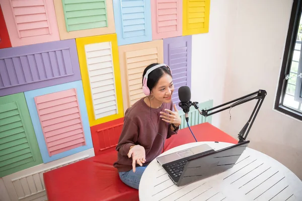 Chica alegre delante del micrófono durante el podcast — Foto de Stock