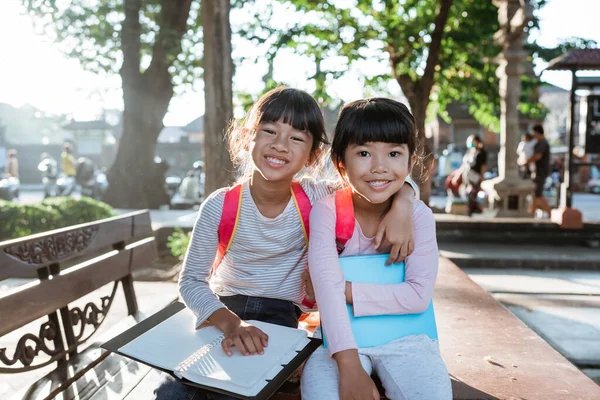 Sorridente due ragazzina studente holding libro — Foto Stock