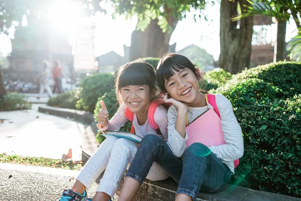 Kleine asiatische Studentin sitzt im Park zusammen — Stockfoto