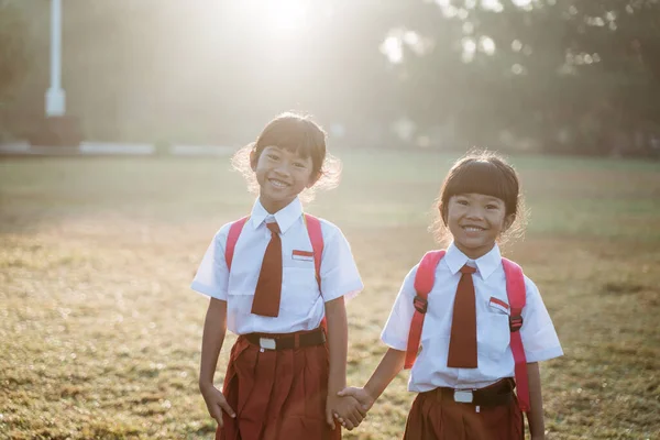 Mutlu Asyalı kız ilkokul öğrencisi birlikte yürür. — Stok fotoğraf