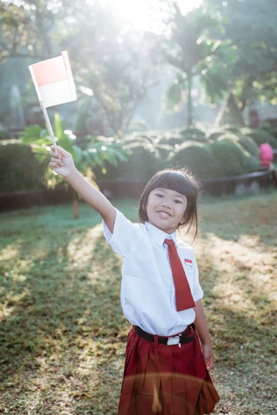 Estudiante de escuela indonesia sosteniendo bandera durante el día de la independencia. —  Fotos de Stock