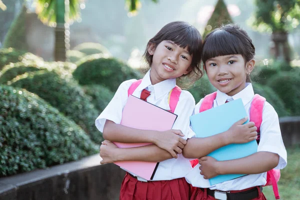 Felice studente amico in uniforme sorridente alla macchina fotografica — Foto Stock