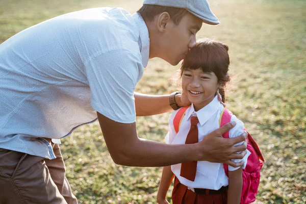 小学校の生徒は学校に行くときに父親の手にキスをし — ストック写真