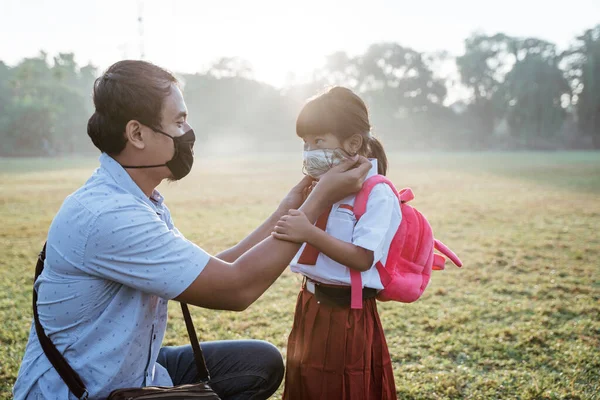 Père aidant sa fille à porter un masque avant d'aller à l'école — Photo