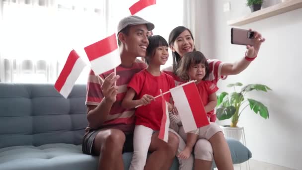 Familia asiática indonesia haciendo selfie y videollamada usando su teléfono en casa — Vídeo de stock