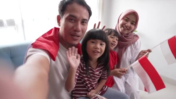 Familia asiática indonesia haciendo selfie y videollamada usando su teléfono en casa — Vídeo de stock