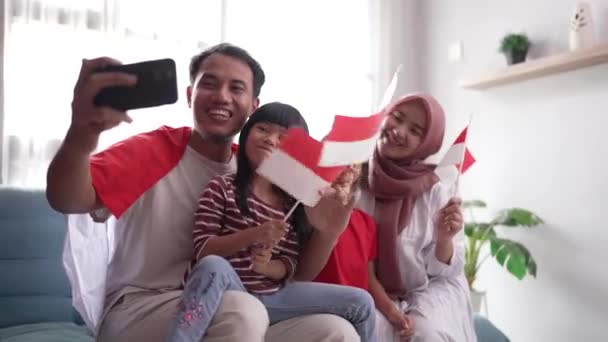 Familia musulmana indonesia haciendo selfie y videollamada usando su teléfono en casa — Vídeo de stock