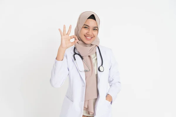 Улыбающаяся женщина-доктор в платке, улыбающаяся зубами с нормальным жестом пальца — стоковое фото
