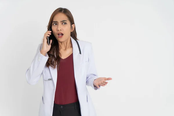 Una dottoressa che indossa un'uniforme bianca è scioccata mentre fa una telefonata con lo spazio — Foto Stock