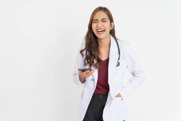 Un medico femminile ride con un'espressione felice mentre usa uno smartphone — Foto Stock