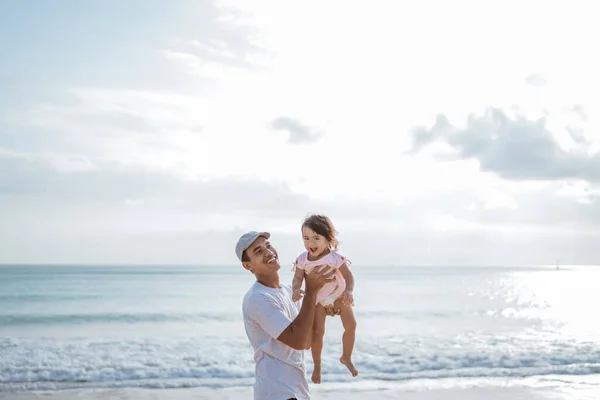 Ο μπαμπάς απολαμβάνει να παίζει με την κόρη του στην παραλία διασκεδάζοντας μαζί. — Φωτογραφία Αρχείου