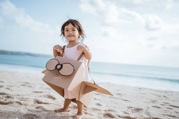 Gamin courir à la plage jouer avec le jouet en carton avion — Photo