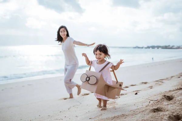 Adorável mãe e filha brincando com avião brinquedo de papelão — Fotografia de Stock