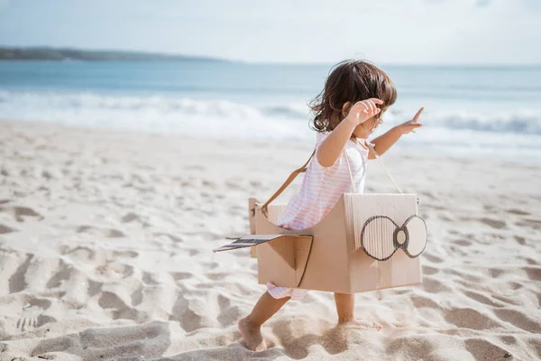 Kind rennt am Strand und spielt mit Pappspielzeug — Stockfoto