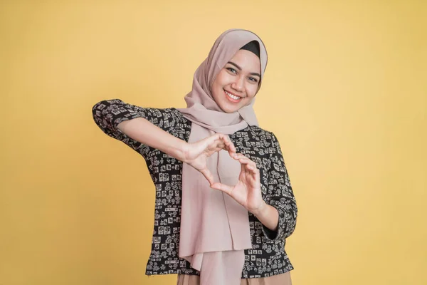Mulher vestindo hijab está gesticulando um coração com os dedos — Fotografia de Stock