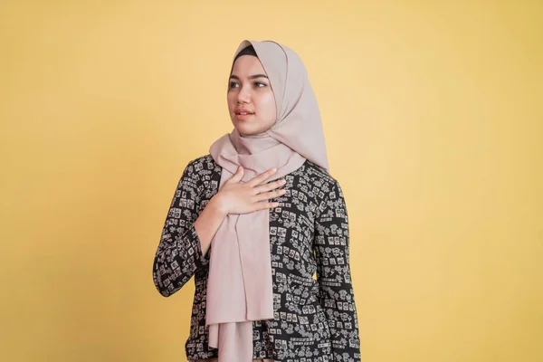 Mujer musulmana usando hijab sosteniendo el pecho con expresión tranquila — Foto de Stock