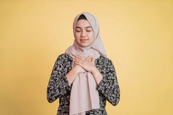 Muslimische Frau im Hijab hält Brust und Augen mit geduldigem Ausdruck geschlossen — Stockfoto