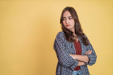 Çapraz elleri olan güzel bir kadın, kopyalama alanının yanında dururken kıskanç bir ifadeyle başka tarafa bakıyor.