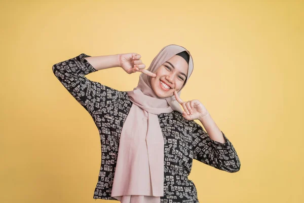 Musulmana hijab mujer dos dedos en la barbilla y sonriendo felizmente — Foto de Stock