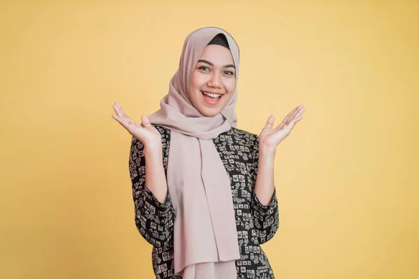 Smiling muslim woman in veil raising hand on chin and smiling happily