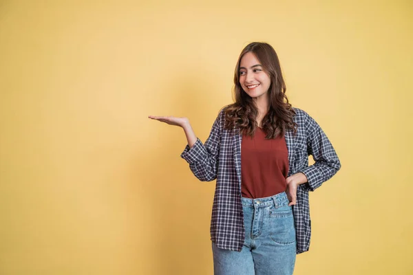 Mulher atraente sorrindo com gesto carregando algo com uma mão com copyspace — Fotografia de Stock