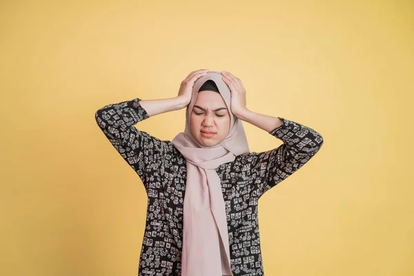 Eine gestresste Frau im Hijab, die im Stehen mit beiden Händen den Kopf hält — Stockfoto