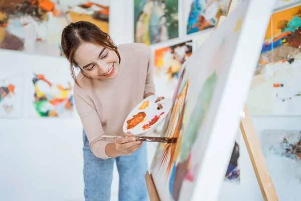 Asiatisk kvinnlig konstnär målning på duk gör några konstprojekt på sin studio verkstad — Stockfoto