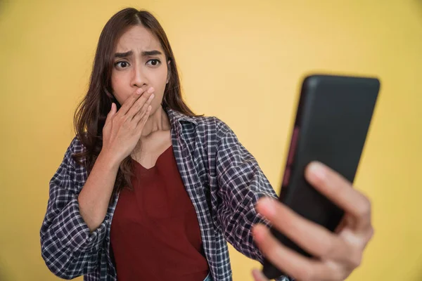 Close up de uma mulher com cabelos longos usando um telefone celular chocado quando ela vê uma tela de telefone celular com copyspace — Fotografia de Stock