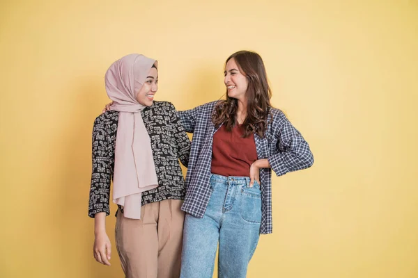 İki güzel müslüman kadın sohbet ederken gülüyor ve ellerinin omuzlarında kopyasal alan ile kucaklaşıyorlar. — Stok fotoğraf