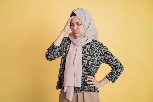 Frau im Hijab schwindelig und gestresst mit Händen, die im Stehen den Kopf und eine Hand auf der Taille halten — Stockfoto