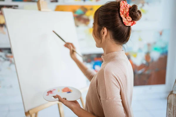 Målare konstnär målning på duk skjuta från hennes rygg — Stockfoto