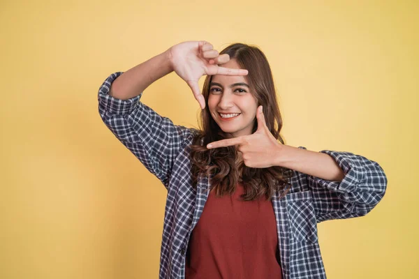 Atraktivní žena usmívající se s gestem dělat rámec pro její hlavu s oběma prsty s copyspace — Stock fotografie