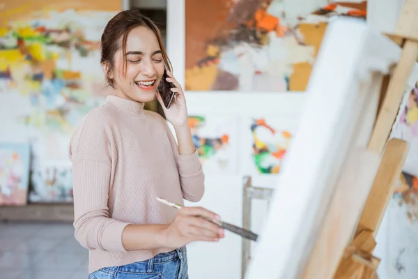 Asiatisk kvinnlig konstnär målning på duk gör några konstprojekt på sin studio verkstad — Stockfoto