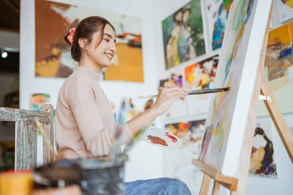 Азіатська жінка живопис на полотні в її майстерні — стокове фото