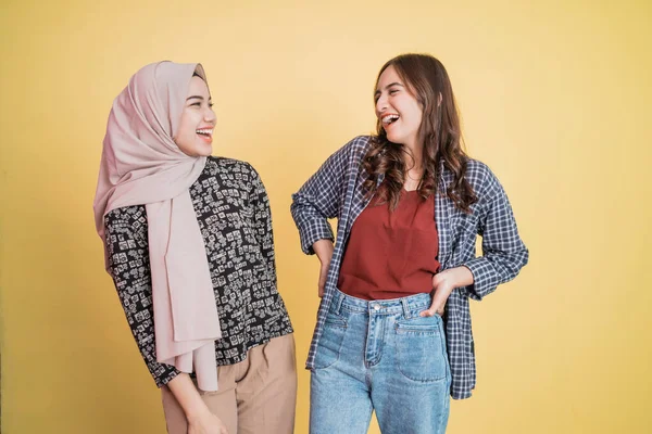 Две женщины, стоящие бок о бок и смеющиеся в шутку — стоковое фото
