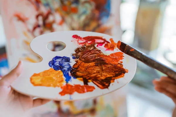 Close up of female painters hand holding a paint brush — Stock Photo, Image