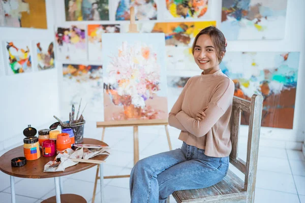 Asiatisk kvinnlig målare målning på duk i sin verkstad — Stockfoto