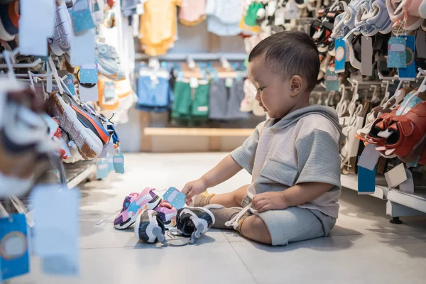 Bebé jugando y arrastrándose en la tienda mientras va de compras —  Fotos de Stock