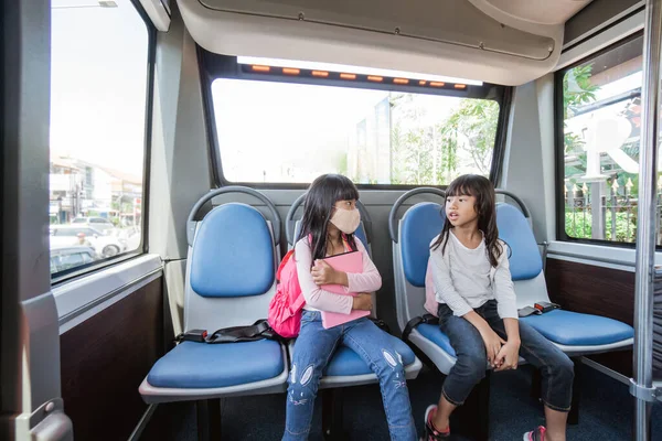 Két ázsiai általános diák megy iskolába busszal tömegközlekedéssel — Stock Fotó