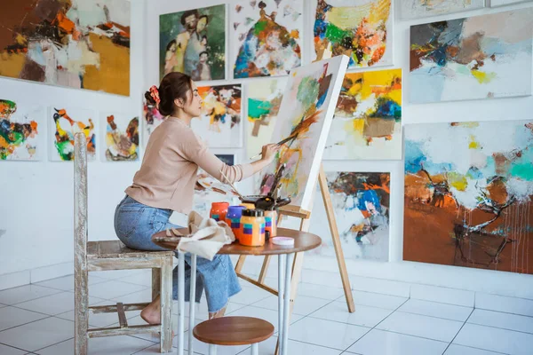 Asiatisk kvinnlig konstnär målning på duk gör några konstprojekt på sin studio verkstad — Stockfoto