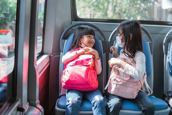 バス公共交通機関で通学しているアジア系の小学生2人が — ストック写真