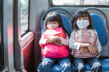 Asyalı öğrenci toplu taşıma araçlarıyla aynı okula gidiyor.