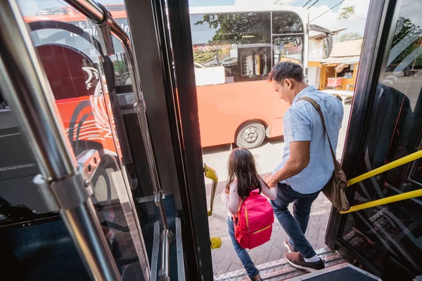 アジア系の父親はバス公共交通機関に乗って娘を学校に連れて行き — ストック写真