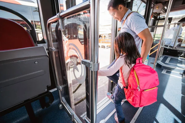 Азіатський батько везе свою дочку до школи, їздячи на автобусі громадського транспорту — стокове фото