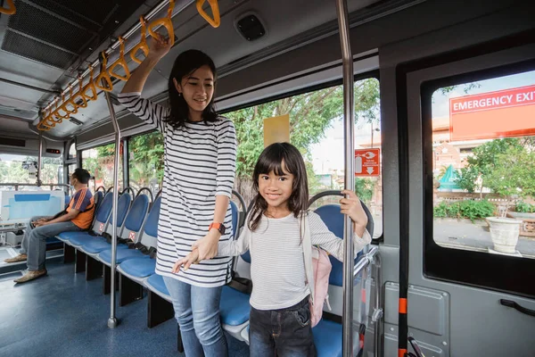 Мати і дочка йдуть до школи вранці на громадському автобусі — стокове фото