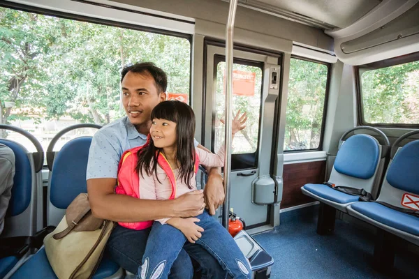 アジア系の父親はフェイスマスクをしたバスの公共交通機関に乗って娘を学校に連れて行き — ストック写真