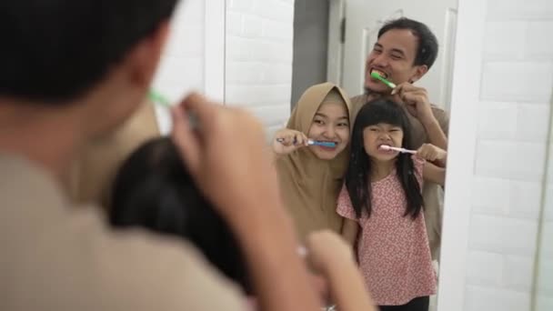 Счастливая азиатская семья чистить зубы вместе — стоковое видео