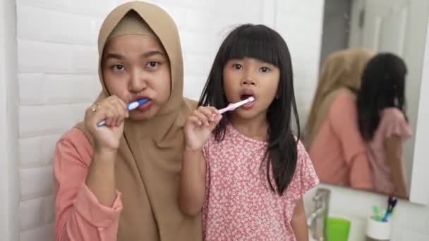 Мать и дочь чистят зубы — стоковое видео