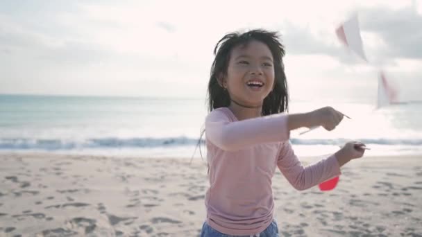 Indonesisches Kind mit Fahne am Strand — Stockvideo