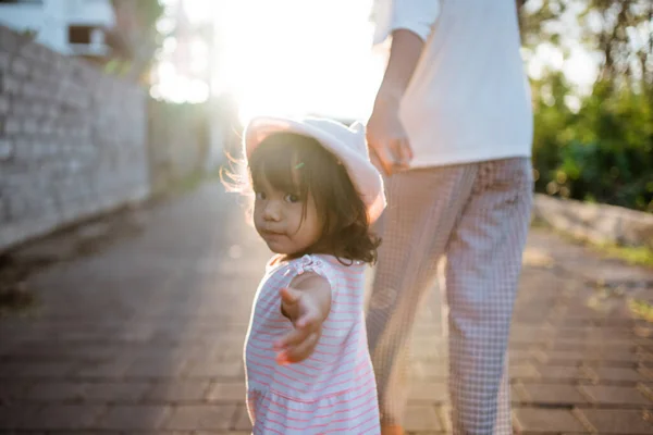 Kind steek haar arm uit vragen om samen te lopen — Stockfoto